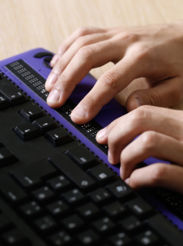A person's hands using a screen reader
